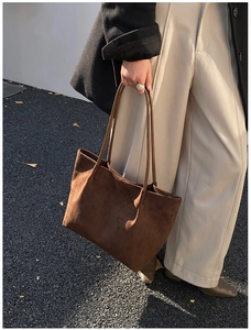 Scatto dinamico della borsa tote in pelle scamosciata marrone con texture opaca