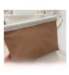 Dettaglio della pochette vintage in pelle stropicciata marrone con bordo in ecopelliccia