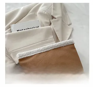 Dettaglio della borsa in ecopelle marrone con bordo in peluche bianco e consistenza