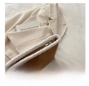 Dettaglio borsa scamosciata marrone con cerniera dorata e bordo in pile bianco soffice