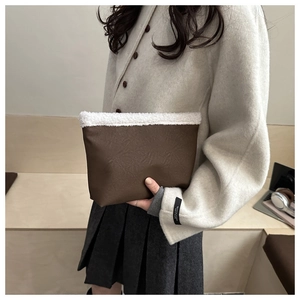 Dettaglio della borsa tote marrone scuro con bordo in montone sintetico e ecopelle