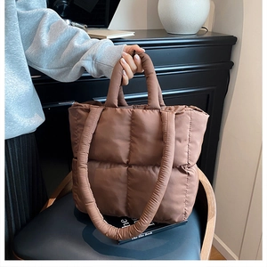 Close-up of dark brown quilted tote bag showing plush padding and nylon texture