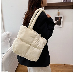 Close-up of cream quilted tote bag with large square stitching and soft padded texture
