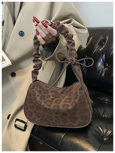 Dettaglio della borsa leopardata con manico arricciato ed elegante fiocco decorativo