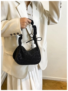 Dettaglio borsa hobo leopardata con tracolla arricciata e decorazione con fiocco nero