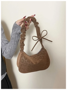 Dettaglio borsa leopardata con manico a nodo e decorazione a fiocco chic
