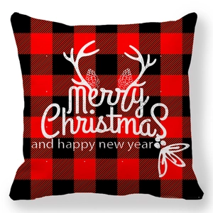 Dettaglio copricuscino natalizio a quadri con scritta Merry Christmas e pigne decorative