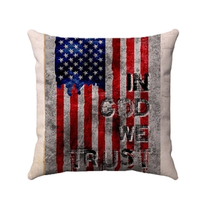 Dettaglio copricuscino in lino rustico con bandiera americana e scritta In God We Trust