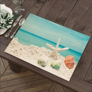 Detail van linnen placemat met zeesterprint op een donkere houten tafel in de keuken