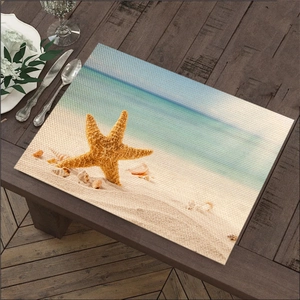 Detail van linnen placemat met zeester en strandopdruk op een houten tafel