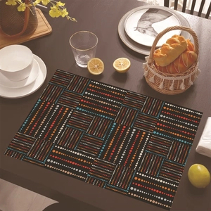 Dettaglio di tovaglietta bohémien in lino con motivi geometrici su tavolo in legno