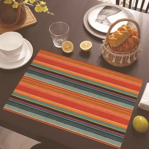 Detail view of colorful Mexican style striped linen placemat on a dark wooden table