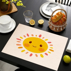 Linen placemat with cartoon sun pattern on dark wooden table with tableware