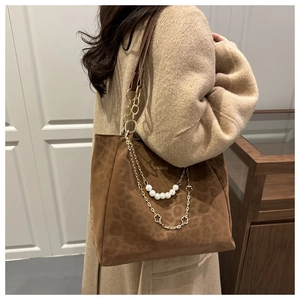 Dettaglio borsa tote leopardata con catena dorata ed elegante tracolla di perle