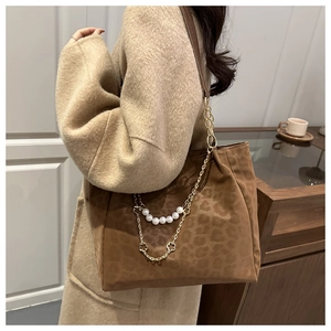 Dettaglio della borsa tote leopardata in pelle scamosciata con perle e catene floreali