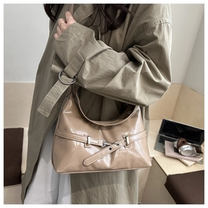 Detail of glossy patent leather shoulder bag with buckle and stylish metal eyelets