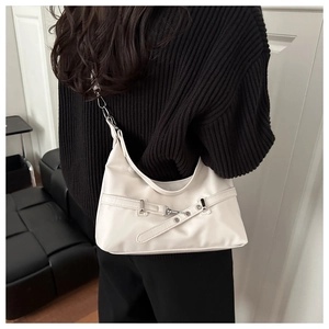 Detail of white half-moon shoulder bag with silver buckles on a stylish model