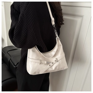 Detail of minimalist beige patent leather half-moon shoulder bag with metal buckle