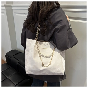 Dettaglio della borsa tote bianca effetto marmo con catena in perle e trifoglio oro