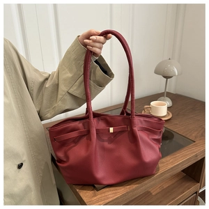 Détail d'un cabas rouge foncé avec cuir texturé litchi et boucle en métal doré