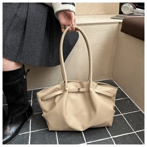 Vue détaillée du grand sac cabas abricot avec texture grainée et boucles métalliques