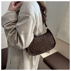Gros plan du sac demi-lune à motif léopard avec boucle métallique dorée sur la bandoulière