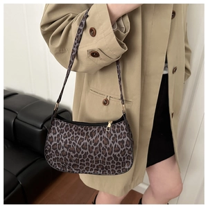Detail of leopard print baguette bag with golden zipper and slim shoulder strap