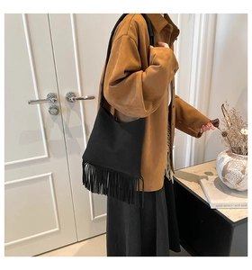 Gros plan du sac hobo en daim noir avec de longues franges et une texture rétro