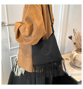 Detail shot of black bohemian fringe tote bag in suede texture with long tassels