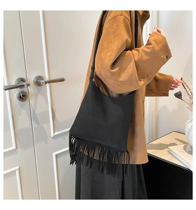 Détail d'un sac bandoulière bohème en daim noir avec de longues franges mates