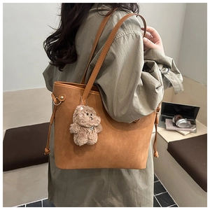 Brown frosted leather tote bag with drawstring side detail and a cute plush bear charm
