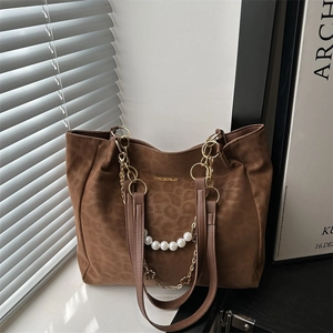 Borsa tote leopardata marrone con catena dorata e ciondoli di perle sul davanzale