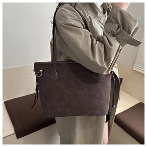 Détail du grand sac cabas en daim marron avec texture mate et boucles métalliques