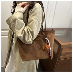 Detail of leopard print brown suede tote bag with teddy charm and silk scarf