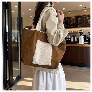 Borsa tote in velluto marrone e shearling bianco in un ambiente di caffetteria