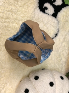 Close-up of camel canvas handbag featuring a blue and white checkered inner lining