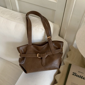 Borsa tote vintage in pelle marrone scuro con fibbia in metallo su divano