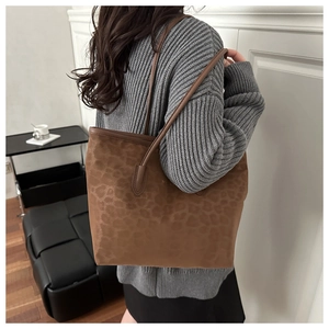 Detail of leopard print faux suede tote bag shown on model for daily commuting size reference