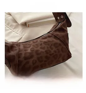 Detail shot of leopard print hobo bag with crescent shape and silver rivet accents