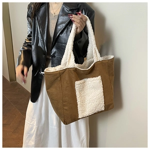 Borsa tote in camoscio marrone con inserti in pile bianco mostrata in scatto lifestyle