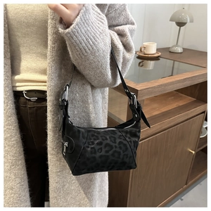Detail view of black leopard print shoulder bag with silver zipper and matte texture