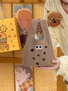 Dettaglio della graziosa borsa in tela marrone con ricamo cartoon e fodera a quadretti blu
