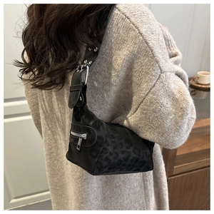 Close-up of leopard print shoulder bag with silver metallic zippers and buckles