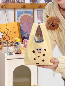 Close-up of yellow canvas cookie bag with cartoon eyes and blue checkered lining