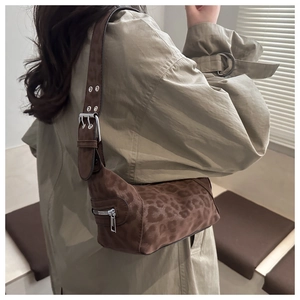 Detail of leopard print tote bag with silver zipper and wide adjustable shoulder strap