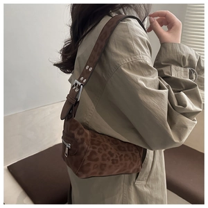 Detail of leopard print hobo bag with adjustable eyelet strap on khaki trench coat