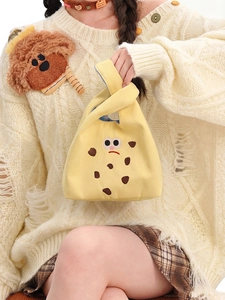 Detail of cute yellow canvas cookie bag featuring cartoon embroidery and blue plaid lining