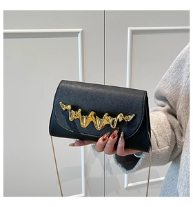 Détail du sac en cuir Saffiano noir avec fermoir ondulé doré et bandoulière chaîne