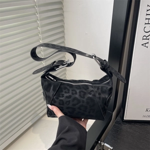 Minimalist black leopard print baguette shoulder bag with wide strap and silver buckle