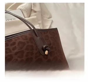 Détail d'un sac cabas léopard avec texture en daim givré et bandoulière en cuir nouée